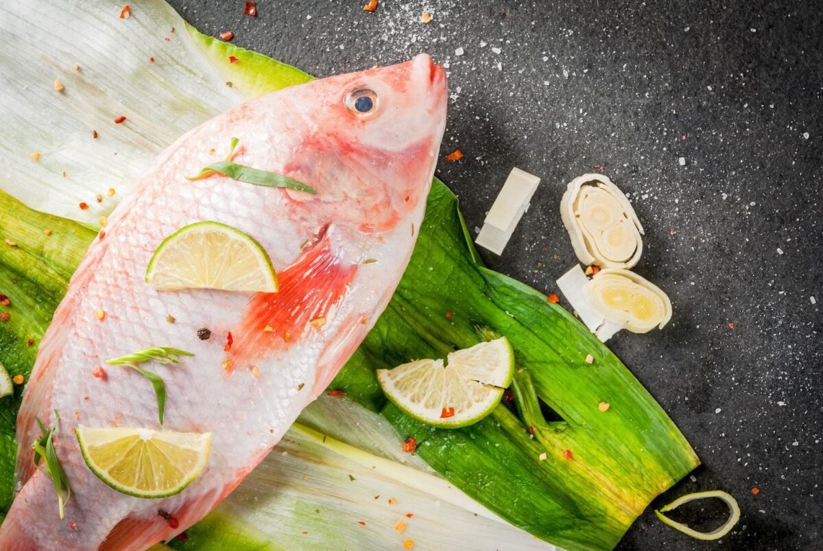 Tilapia on leaves with lime slices