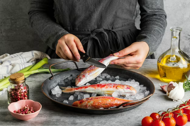 Woman preparing fish for cooking