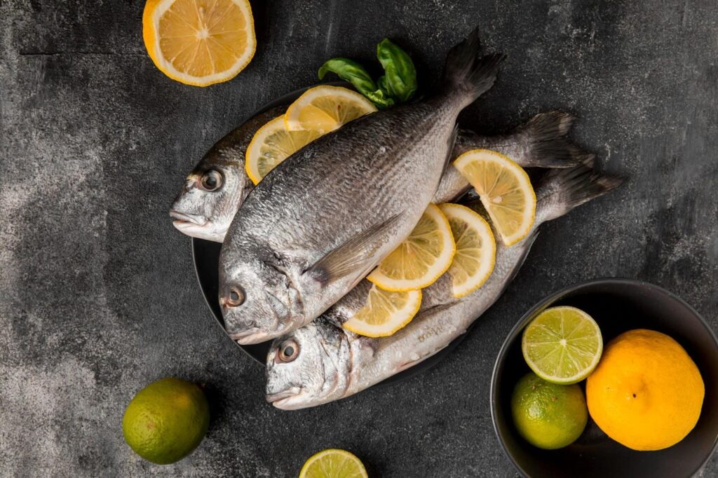 Top view of uncooked seafood fish with slices of lemon